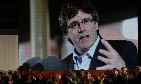 Ousted Catalan president Carles Puigdemont appears on a giant screen during an election event in Barcelona