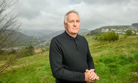 Meirion Thomas posing with a valley landscape in the background