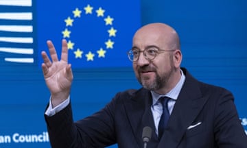 Charles Michel gestures with an open hand in front of an EU flag backdrop at a press conference