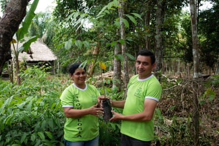 Neida Pereira and Raimundo Feleol hold a mahogany seedling