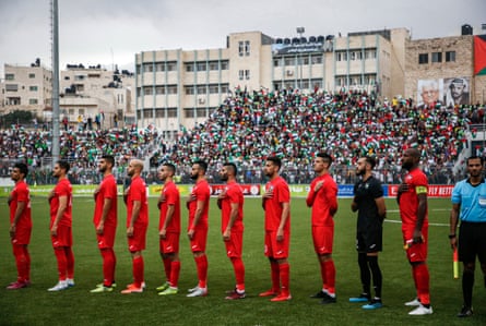 Palestine's starting XI line up for the national anthem before a 2022 World Cup qualifier against Saudi Arabia in the town of al-Ram in the Israeli occupied West Bank in 2019