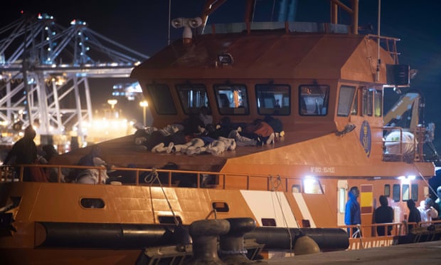 People rescued off Gibraltar prepare to spend the night onboard a Spanish rescue boat at the port of Algeciras, Spain.