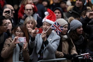 Spectators take photographs as dancers perform during the New Year’s Day parade in London