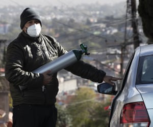 Ricardo Ledesma Carrasco se sube a su  automóvil después de llenar un tanque de oxígeno en una tienda para su padre, quien está siendo tratado por Covid-19 en su casa en la Ciudad de México.  La madre de Carrasco también tiene Covid-19.