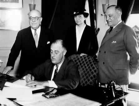 Franklin D Roosevelt signs a bill at the White House in 1933.