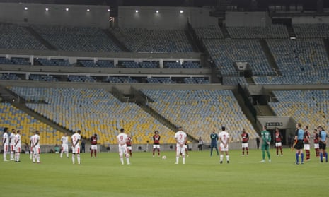 Players of Bangu, wearing white uniforms, and Flamengo pay a minute of silence for the victims of the coronavirus prior to a Rio de Janeiro soccer league match at the Maracana stadium in Rio de Janeiro, Brazi, Thursday, 18 June 2020.
