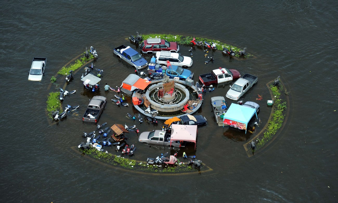 Vehicles are stranded in floodwaters at a roundabout in the ancient city of Ayutthaya, Thailand.