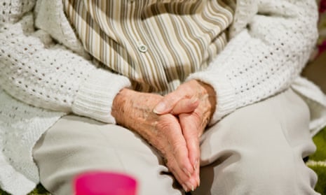 A woman with dementia clasps her hands together