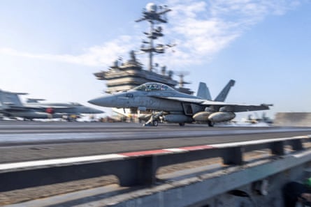 A military aircraft on the deck of a carrier ship.