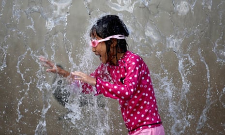 A girl plays in a fountain to cool down in a Tokyo park
