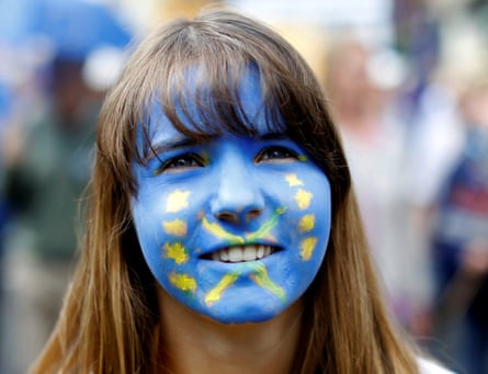 A woman wears face paint in the colours of the European flag.