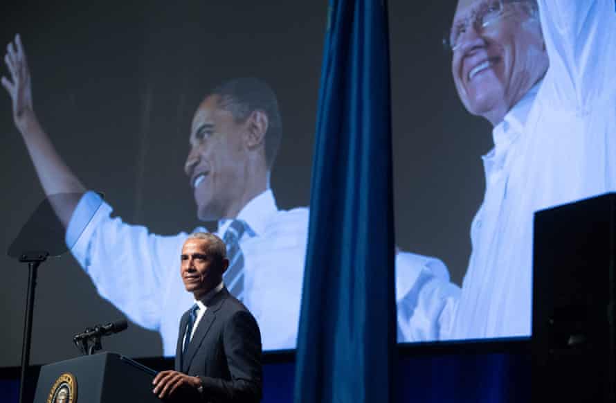 Barack Obama speaks in front of his photo with Reed in 2008.