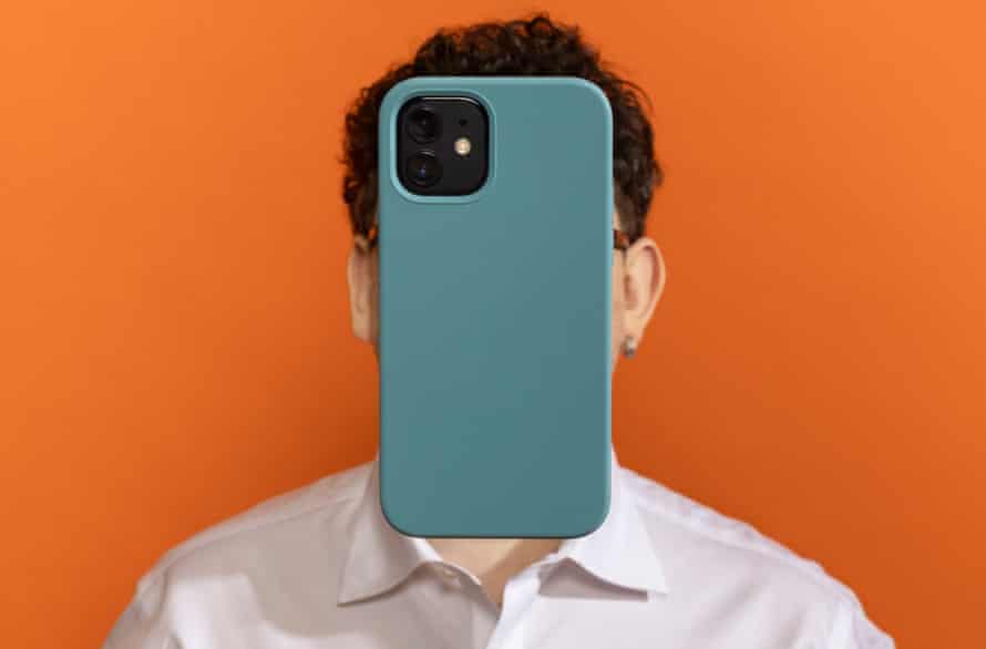 Headshot of James Ball with a smartphone obscuring his face, against an orange background
