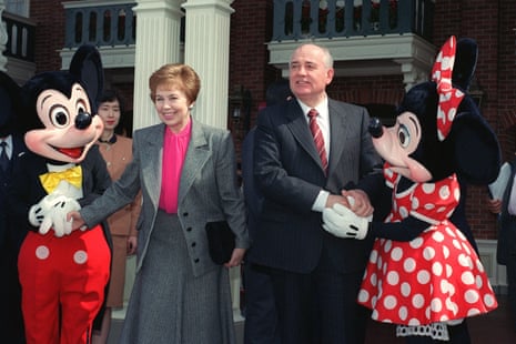Former Soviet leader Mikhail Gorbachev and his wife Raisa shake hands with Mickey and Minnie Mouse at the entrance of Tokyo Disneyland on 12 April, 1992.