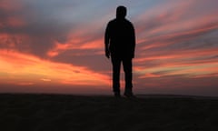 Silhouette Man Standing On Field Against Sky During Sunset