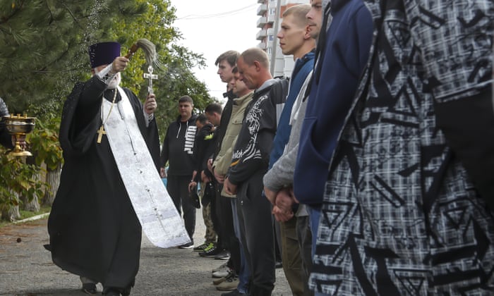 A Russian Orthodox priest blesses a group of recruits at a military recruitment center in Volgograd, Russia.