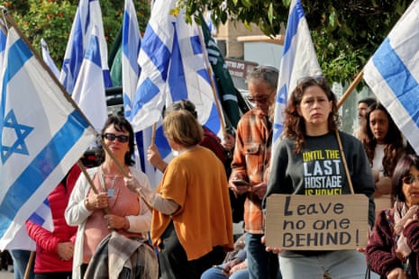 Mourners holding flags and signs wait outside the morgue in Rishon LeZion in central Israel for the funeral procession of French-Israeli national Ohad Yahalomi.