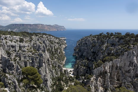 A view of clear blue sea at a rocky inlet between two cliffs.