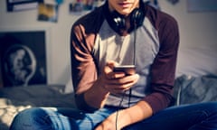 Teenage,Boy,In,A,Bedroom,Listening,To,Music,Through,His<br>Teenage boy in a bedroom listening to music through his smartphone; Shutterstock ID 1090254734; purchase_order: -; job: -; client: -; other: -