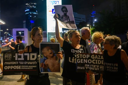 Protesters hold photos of emaciated children during a protest in Tel Aviv against the expansion of the war in Gaza on Friday.