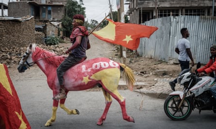 Man rides the horse and carries a flag