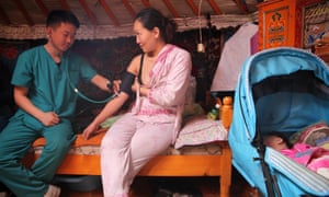 A doctor screens a woman for blood pressure problems