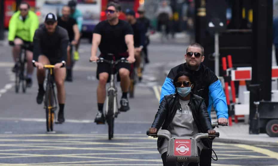 People cycling wearing face masks as a precaution are seen on Oxford Street in London