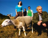 The four members of Jawdropped photographed standing around a lamb