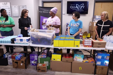 people stand at a table with donated goods