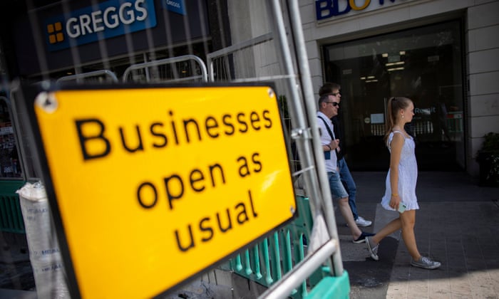 People walking past high street shops and restaurants in London in July.
