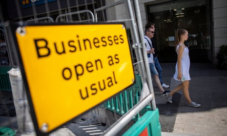 A picture of sign saying "businesses open as usual" on a UK high street.