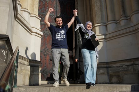 two people smile and walk hand in hand