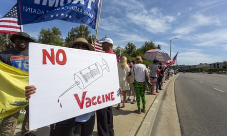 A protester holds an anti-vaccination sign on 16 May 2020 in Woodland Hills, California. 