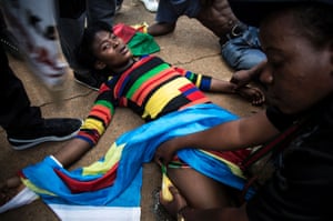 A Congolese protester lies on the ground after police opened fire with rubber bullets as they demonstrated outside the Democratic Republic of Congo’s embassy in defiance of their president, Joseph Kabila