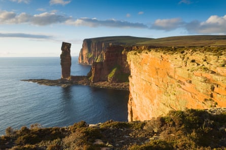 A tall sea stack near cliffs