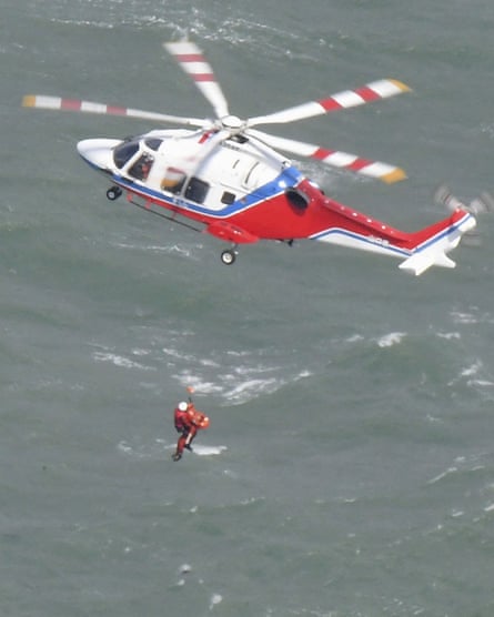 A helicopter conducts a search and rescue operation after a tanker capsized off Japan