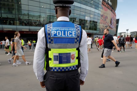 An Arsenal operational football officer from the Met Police acting as a spotter near the away fans entrance on the podium level before kick off in the Premier League match between Arsenal and Chelsea