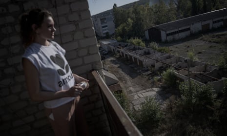 Alyona looks out from the balcony of her house damaged during the Russian attack.