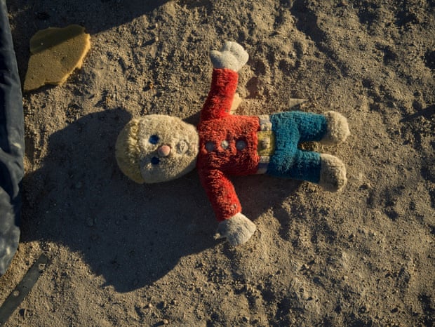 A stuffed animal is discarded in the desert sand
