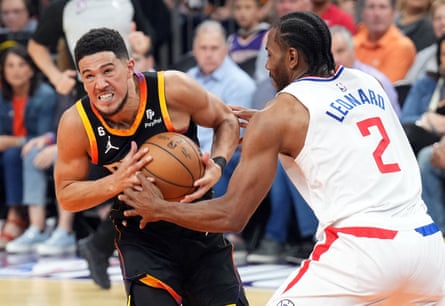 Suns guard Devin Booker, left, drives against Clippers forward Kawhi Leonard during the first half of Sunday’s Game 1.