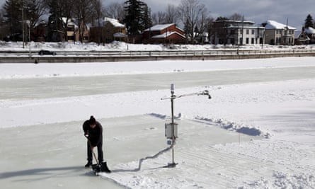 Prof Shawn Kenny cleans snow around a mini weather station set up on the Rideau canal in February.