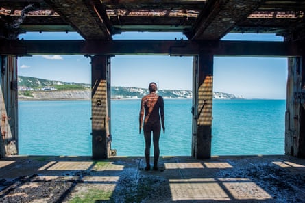 One of Antony Gormley’s Another Time figures gazes out to sea from Folkestone Pier.