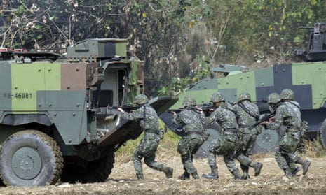 Taiwan soldiers walk behind an armoured personnel carrier during an annual military drill in Taichung, central Taiwan, in 2017.