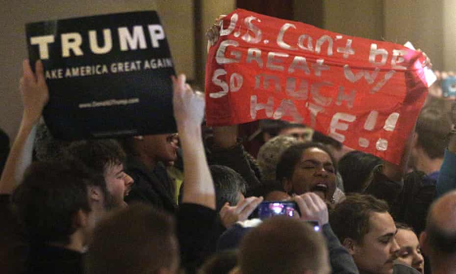 Police attempt to remove protesters as Republican presidential candidate Donald Trump speaks during a campaign rally.