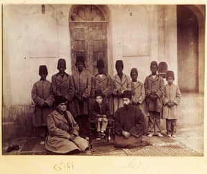 This photo was probably taken by Masoud Mirza Zell-e-Soltan (1850-1918), governor of Isfahan (1872-1907), and the eldest son of Nasser al-Din Shah. Zell-e-Soltan’s son Bahram Mirza sits in the middle on a chair accompanied by two members of his court (Reza Qoli Khan, private secretary in the right and Aqabaji eunuch chief in the left) sitting on the right and eight African eunuchs. The design of the jacket and hat of the Africans slaves could be considered a type of ethnic segregation.