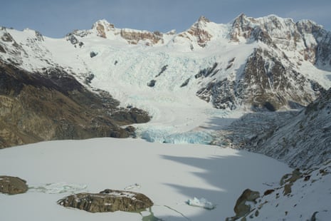 A frozen lake amid snowy mountains.