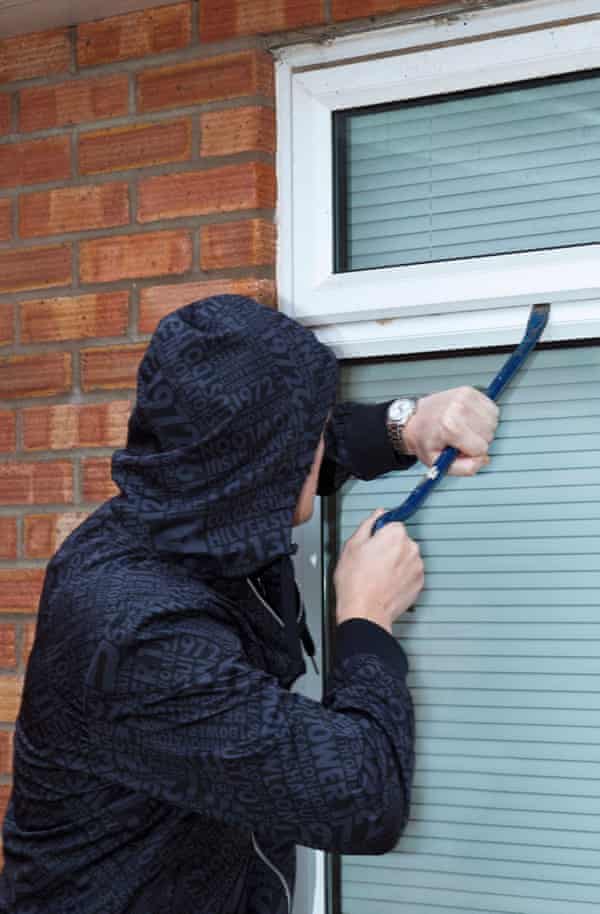 Smart security: how to keep your home safe while you’re away 11 A man tries to force open a window on a house.