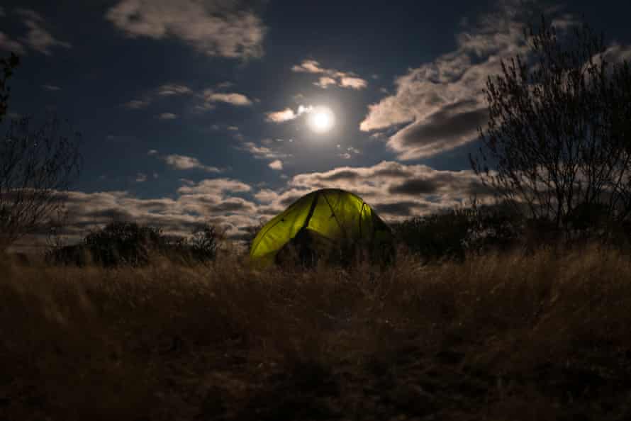 The full moon rises over a tent