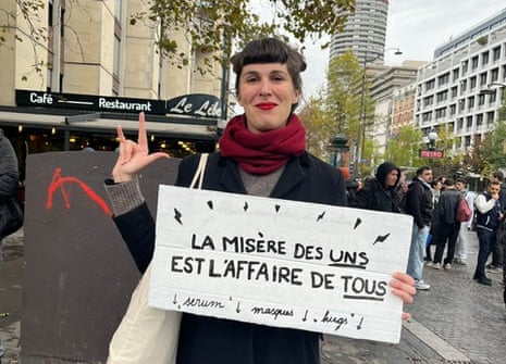 Emma holding a sign that reads: “The suffering of a few is the concern of all”