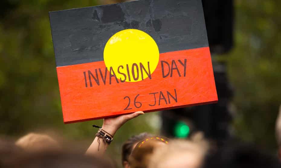 A protestor holds a sign during a march through Melbourne, campaigning against holding Australia Day on 26 January.